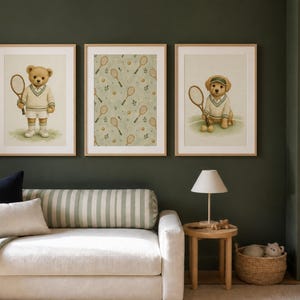 A living room scene featuring a cream sofa against a dark green wall with three framed tennis prints hanging above.