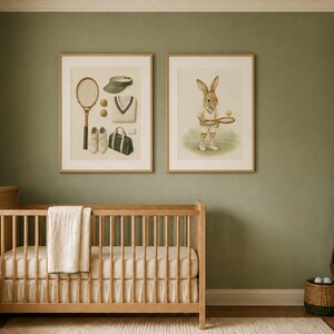 May include: Two framed wall art prints featuring tennis-themed illustrations. The left print displays a tennis racket, visor, balls, sweater, and bag. The right print shows a rabbit holding a tennis racket and ball. Both are in light wood frames.