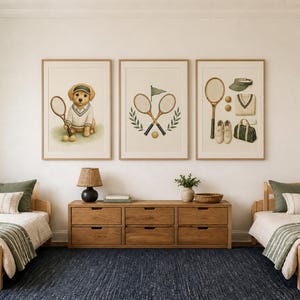 May include: Three framed wall art prints featuring tennis-themed illustrations. The left print shows a golden puppy with a tennis racket, the center print displays crossed rackets with a flag, and the right print depicts tennis gear including a racket, visor, sweater, shoes, and bag.