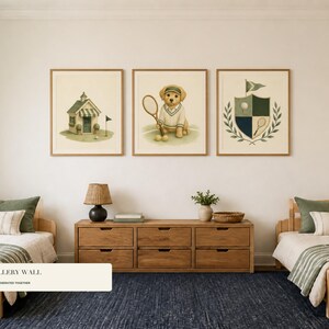 May include: Three framed wall art prints featuring illustrations of a golf clubhouse, a puppy wearing a tennis outfit with a racket, and a crest with a golf ball and tennis racket, displayed above a wooden dresser between two twin beds.