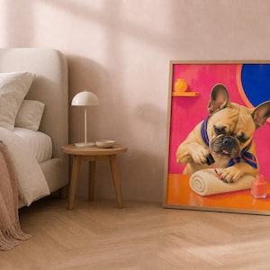 A framed art print of a French bulldog painting its nails leans against a wall in a bedroom next to a bed and a small table.