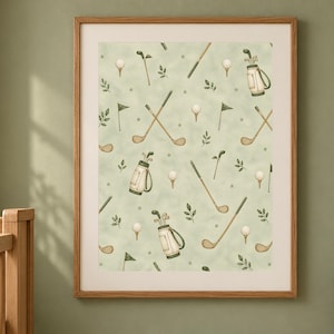A framed watercolor golf pattern print hangs on a sage green wall next to a wooden crib and a vase of greenery.