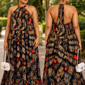 May include: A floor-length halter neck dress featuring a black, brown, and red geometric print with white linear accents. The dress has a gathered neckline, a tiered ruffled hem, and an open back design with tie closures at the neck.