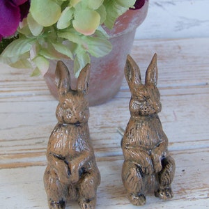 May include: Two brown ceramic rabbit drawer pulls with a distressed finish. The rabbits are sitting upright with their paws crossed.