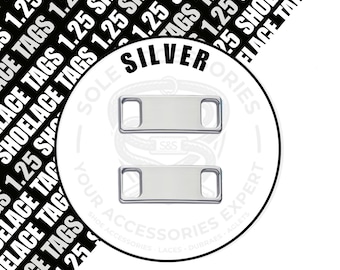 May include: Two rectangular silver-coloured metal shoelace tags with rounded corners and two slots for laces. The background features repeating black text that reads 1.25 SHOELACE TAGS and a circular logo with the text SILVER, SOLE S&S, and YOUR ACCESSORIES EXPERT.