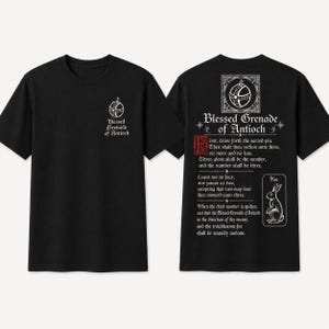 May include: A black short-sleeve t-shirt featuring a small white graphic of a grenade on the front chest with the text Blessed Grenade of Antioch. The back displays the same grenade icon, the title, and a lengthy instructional text with a rabbit.