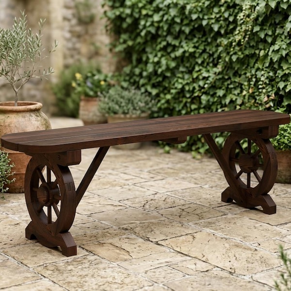 May include: A dark brown wooden bench featuring a long, rectangular seat supported by two legs designed in the shape of circular wagon wheels with spokes. The bench has a smooth, stained finish and a sturdy frame construction.