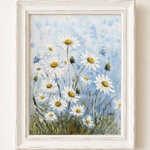 May include: An oil painting of white daisies with yellow centers set against a textured light blue background, featuring green stems and foliage at the base, all enclosed within a distressed white wooden frame with a rectangular border.