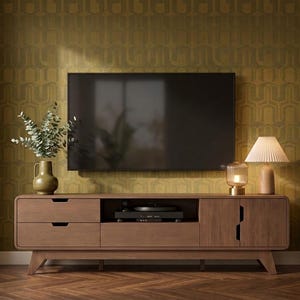 May include: A long, rectangular wooden media console with rounded edges, featuring two stacked drawers on the left, an open center shelf containing a black electronic device, and a cabinet door on the right, set against a mustard yellow patterned wall.