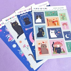 May include: A set of six colorful sticker sheets featuring cats in various poses and settings. The sheets are labeled "Paper Cat Club" and "Stamp Collector".