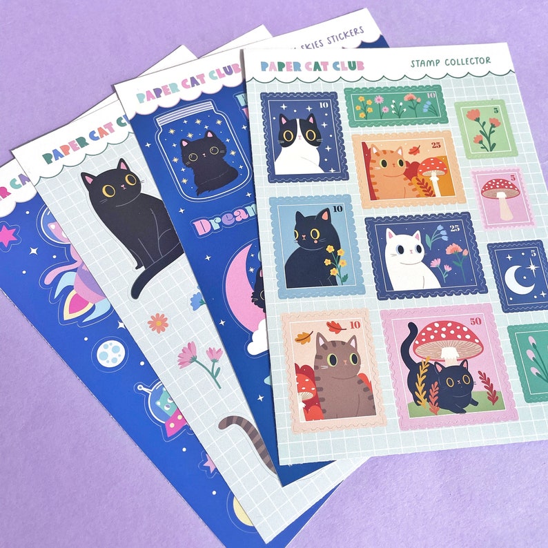 May include: A set of six colorful sticker sheets featuring cats in various poses and settings. The sheets are labeled "Paper Cat Club" and "Stamp Collector".