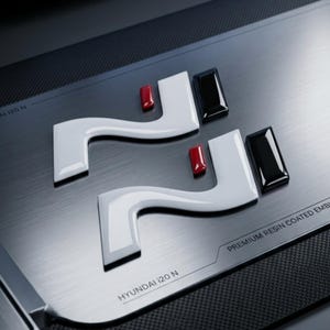 Op de afbeelding: Twee witte N-vormige emblemen met rode en zwarte accenten op een geborsteld metalen oppervlak. De tekst HYUNDAI i20 N en PREMIUM RESIN COATED EMBLEMS staat op de zilveren plaat met een donkere, getextureerde rand.