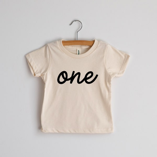 One First Birthday Organic Kids T-Shirt • Modern Script Lettered Shirt for Trendy One Year Olds • Natural Cream Organic Birthday Tee