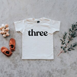 Camiseta de tercer cumpleaños • Camiseta estampada de algodón orgánico para cumpleaños • Camiseta orgánica moderna de color crema para niños de 3 años y de género neutro