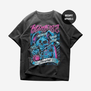 May include: A charcoal gray t-shirt featuring a graphic print of a blue skull with rabbit ears holding a tattoo machine and a boombox. The text reads Blink-182, Matt Skiba, Yelawolf, Prayers, The 8th Annual Musink, March 22, 2015, Costa Mesa, CA.