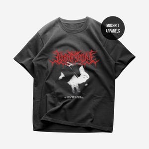 Könnte beinhalten: Ein anthrazitfarbenes Kurzarm-T-Shirt mit einem roten, stilisierten Metal-Logo im oberen Bereich, einer weißen Grafik einer nach unten greifenden Hand in der Mitte und dem Text "even inside a dream the world has no meaning" darunter.