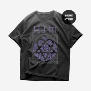 May include: A black short-sleeve t-shirt featuring the text HIM in purple above a circular graphic containing purple roses arranged in a pentagram shape. The design is enclosed in a square border with ornate details and the text MOSHPIT APPARELS.
