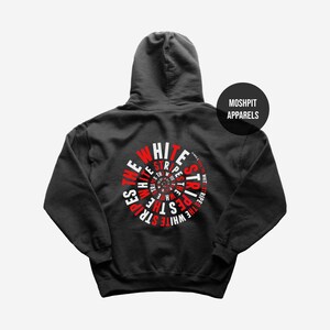 May include: A black hooded sweatshirt featuring a circular graphic on the back with the text THE WHITE STRIPES in repeating red and white letters arranged in a spiral pattern. A black circular logo with the text MOSHPIT APPARELS is visible.