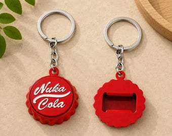 May include: Two red metal bottle opener keychains with silver-toned split rings and chains. One keychain features the white text Nuka Cola on a circular bottle cap design, while the other shows the reverse side with a rectangular bottle opener cutout.