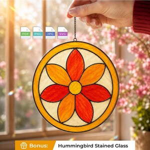 May include: A circular stained glass suncatcher featuring a central yellow circle surrounded by six alternating orange and red petals, all enclosed within a yellow border. The design is framed by black metal lines and hangs from a thin metal chain.