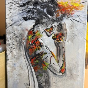 May include: An abstract painting on canvas depicting a figure with a head of dark, textured black paint. The body is rendered in shades of gray with vibrant patches of red, orange, and yellow paint, creating a stark contrast against the light gray background.