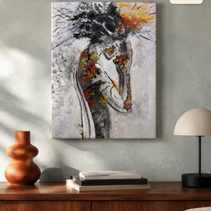 May include: A rectangular canvas wall art piece measuring 11x14 inches, featuring an abstract painting of a figure in profile. The artwork uses a palette of black, white, gray, and vibrant orange and yellow accents to depict a textured, expressive form.