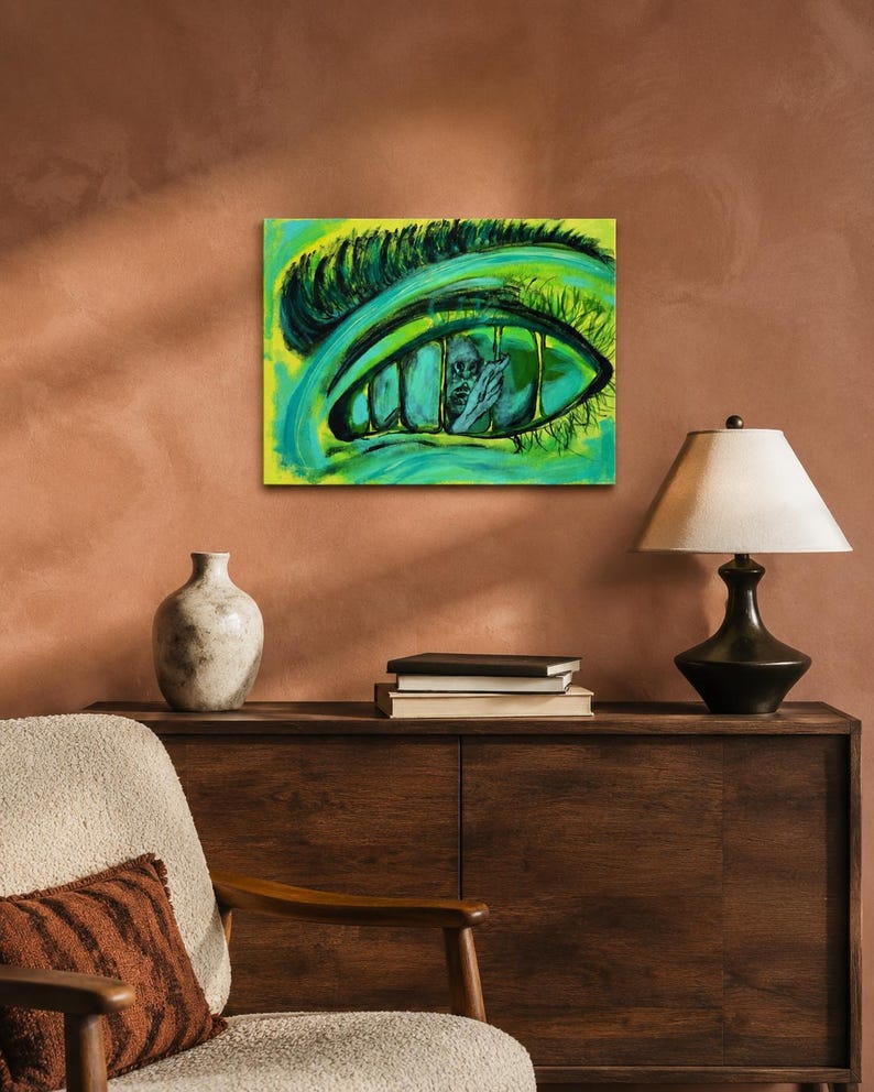 May include: A rectangular canvas painting featuring a large, stylized human eye rendered in vibrant shades of lime green and teal. The iris contains a dark, detailed illustration of a figure trapped behind vertical bars, set against a bright background.