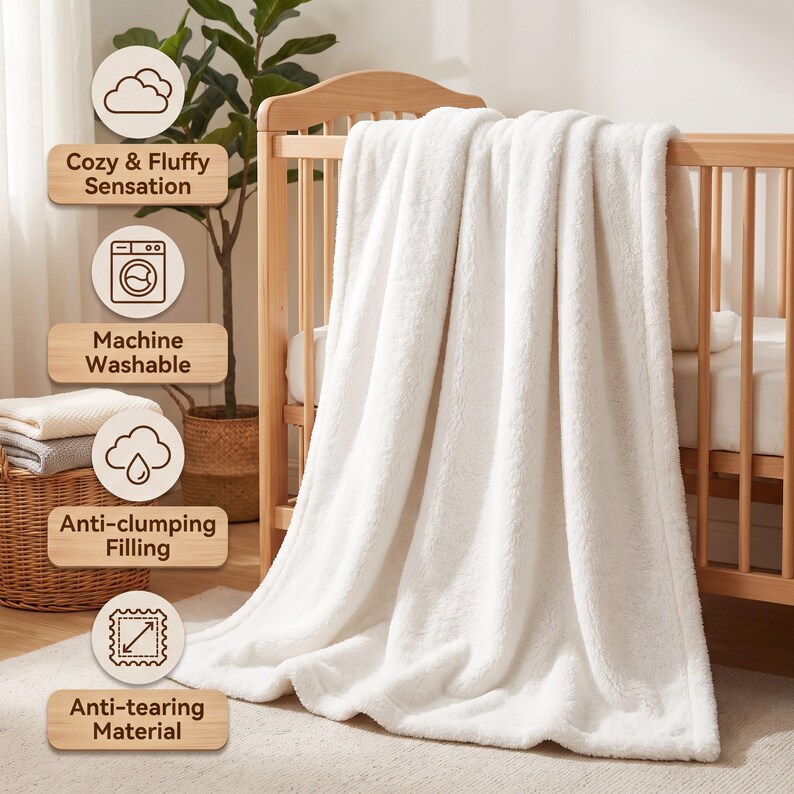 May include: A soft white fleece blanket draped over a wooden crib. The image includes text labels: Cozy & Fluffy Sensation, Machine Washable, Anti-clumping Filling, and Anti-tearing Material, each accompanied by a corresponding icon.