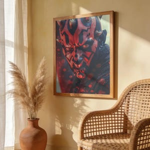 Könnte beinhalten: Ein gerahmter Wandkunstdruck mit einem Nahporträt der Star Wars-Figur Darth Maul, gekennzeichnet durch seine roten und schwarzen Gesichtstätowierungen, gelben Augen und Hörner, vor einem dunklen Hintergrund mit roten Lichteffekten.