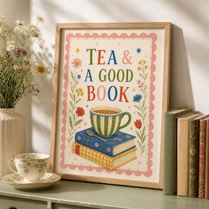 May include: A framed wall art print featuring the text TEA & A GOOD BOOK in colourful letters. The illustration shows a green and white striped teacup on a stack of two books with a small spoon, surrounded by floral motifs and small stars.
