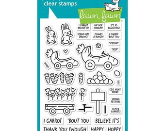 May include: A set of photopolymer clear stamps by Lawn Fawn featuring outlines of rabbits, carrot-shaped cars, carrots, eggs, flowers, a wagon, and a sign. Text includes phrases like I CARROT BELIEVE IT, HIP HOP HOORAY, IT'S SO EGGciting, and SPRING IS ON ITS WAY.