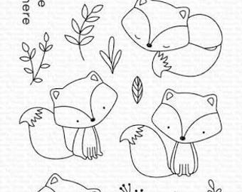 May include: A clear photopolymer stamp set featuring black line art illustrations of four foxes in various poses, two mushrooms, and several leafy sprigs. The text includes: You Make Being Foxy Look Easy, Let's Curl Up Together, Happiest Birthday Ever, I'm Sitting Here Wishing I Was There.