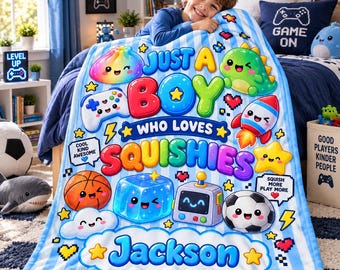 May include: A light blue and white striped fleece blanket featuring colorful cartoon graphics of a basketball, soccer ball, rocket, robot, and various squishy characters with the text Just A Boy Who Loves Squishies and Jackson.