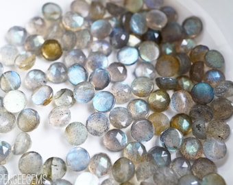 May include: A collection of round, faceted labradorite gemstones in shades of gray, blue, and green. The stones have a shimmering, iridescent quality.