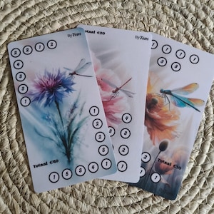 Op de afbeelding: Drie rechthoekige cadeaubonnen met illustraties van bloemen en libellen. Elke kaart bevat de tekst By Fem, cijfers in cirkels en totaalbedragen van 40, 20 en 30 euro. De ontwerpen tonen een blauwe, een roze en een oranje bloem.