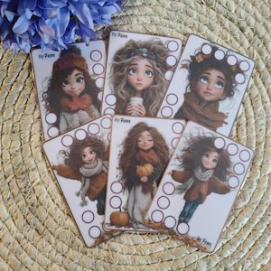 Op de afbeelding: Vijf rechthoekige kaarten met illustraties van personages met bruin haar in herfstkleding, elk met de tekst By Fem en lege cirkels voor tracking. De personages dragen sjaals, truien en houden pompoenen of bladeren vast in hun handen.