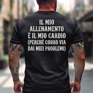 Può includere: Una t-shirt nera a maniche corte con testo bianco stampato sul retro: IL MIO ALLENAMENTO È IL MIO CARDIO (PERCHÉ CORRO VIA DAI MIEI PROBLEMI). Il capo presenta un girocollo ed è realizzato in tessuto nero tinta unita con scritte in evidenza.