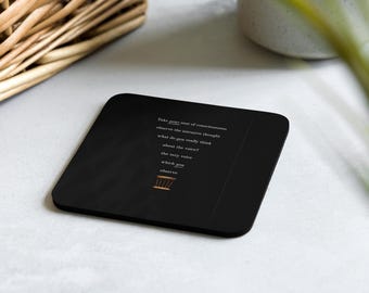 Porta-copos de cortiça com frase inspiradora sobre atenção plena e reflexão tranquila.