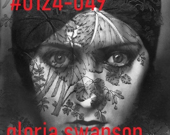 May include: A black and white portrait of Gloria Swanson from 1923, featuring a face partially obscured by a dark, intricate lace veil with floral patterns. The image includes the red text #0124-049, gloria swanson, and 1923 overlaid on the print.