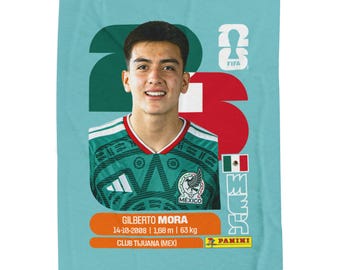 May include: A rectangular light blue trading card featuring a portrait of soccer player Gilberto Mora wearing a green Mexico jersey. The card displays the text Gilberto Mora, 14-10-2008, 1.68 m, 63 kg, Club Tijuana (MEX), FIFA logo, and Panini logo.
