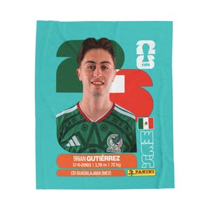 May include: A rectangular teal blanket featuring a portrait of soccer player Brian Gutiérrez in a green Mexico jersey. The design includes the number 23, the FIFA logo, the Mexican flag, and text detailing his birth date, height, and weight.