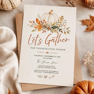 Peut inclure: Une carte d'invitation rectangulaire pour un dîner de Thanksgiving avec une illustration à l'aquarelle d'une citrouille blanche entourée de feuilles d'automne et de baies. Le texte indique Let's Gather for Thanksgiving Dinner, Saturday, November 22, 2026, at 5:30 PM, The Johnson Home, 128 Maple Grove Road, Oakville, Ontario L9T 6B3, RSVP to Camille by November 10, 630.555.8421, camille@email.com.