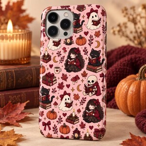 Può includere: Una cover per smartphone rosa con un motivo ripetuto di illustrazioni a tema autunnale che include fantasmi, gatti neri, zucche, teschi, libri, candele, foglie d'acero e bambine, tutte intente a leggere dei libri.