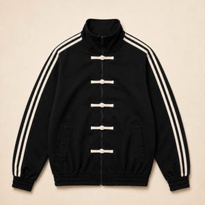 May include: A black track jacket featuring a high collar, a full-length front zipper, and five white toggle closures down the center. The sleeves are adorned with two white stripes running from the collar to the ribbed cuffs at the wrists.