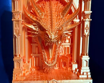 May include: A metallic orange 3D printed book nook insert featuring a highly detailed dragon head emerging from an arched architectural structure with columns, a shield emblem at the top, and a smaller shield emblem at the base of the platform.