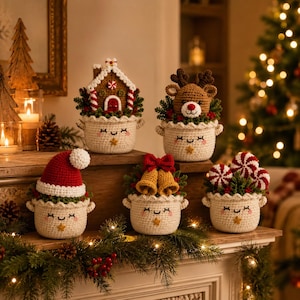 May include: Five crocheted cream-colored pots with smiling faces, each containing a different Christmas-themed topper: a gingerbread house, a reindeer head, a red Santa hat, two gold bells with a red bow, and three red-and-white peppermint candies.