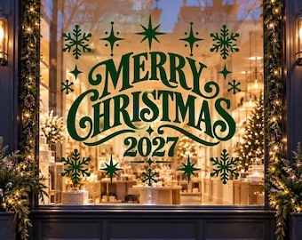 Könnte beinhalten: Ein dunkelgrüner Vinyl-Fensteraufkleber mit dem Text Merry Christmas 2027 in einer stilisierten Schreibschrift, umgeben von verschiedenen Schneeflocken und vierzackigen Sternen, angebracht auf einer Schaufensterscheibe mit Weihnachtsbeleuchtung.