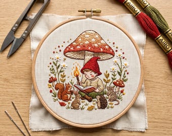 May include: An embroidery hoop containing a fabric panel with a stitched scene of a person in a red hat reading a book under a large mushroom, surrounded by a squirrel, rabbit, hedgehog, mouse, and flowers, with embroidery scissors and thread.