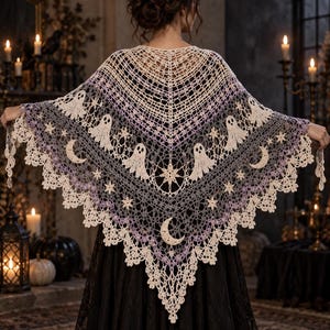 May include: A triangular crochet shawl featuring a gradient color scheme transitioning from cream to light purple and dark gray. The intricate lace pattern includes repeating motifs of small ghosts, crescent moons, and stars, finished with a scalloped edge.