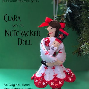 May include: A felt ornament pattern for a plush doll of Clara from the Nutcracker ballet. The doll is holding a Nutcracker doll. The pattern is hand embroidered and includes a red and white dress with sequins.